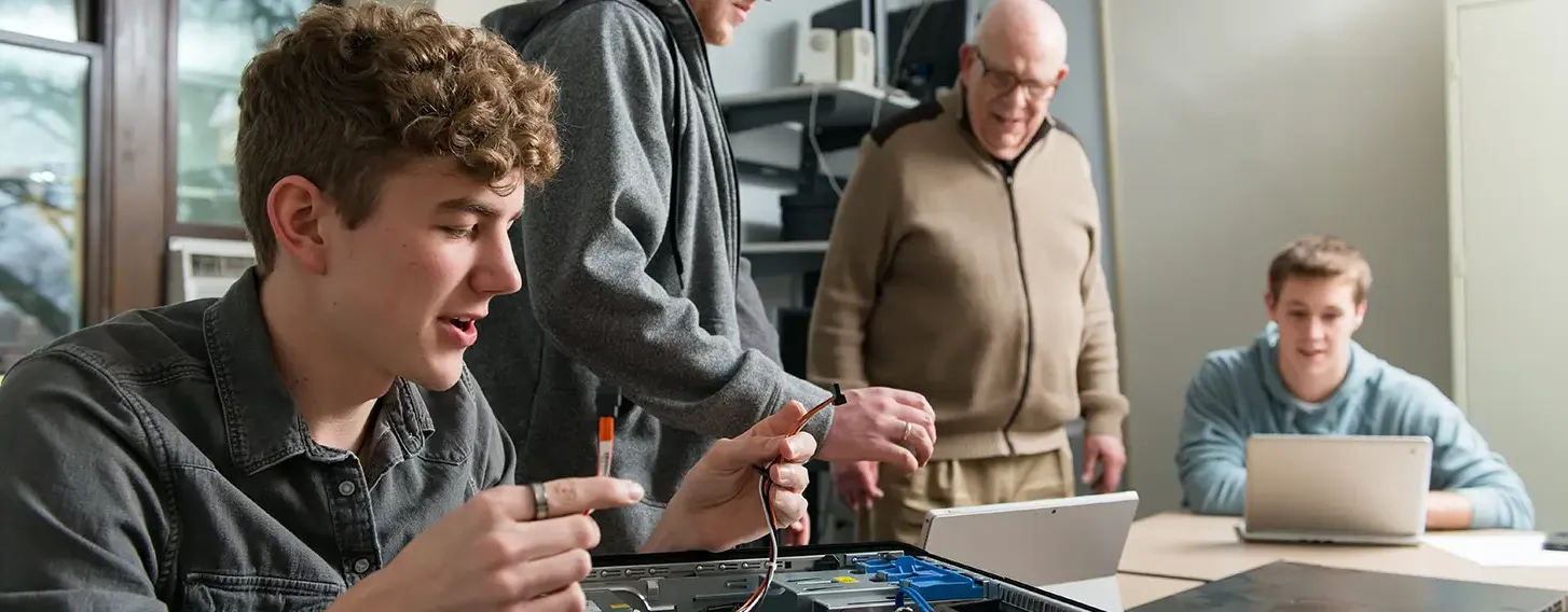 A group of people working on the parts of a computer.